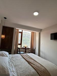 1 dormitorio con cama, mesa y ventana en JUAN PLACIDO Hotel, en Cusco