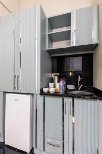 a kitchen with white cabinets and a white refrigerator at Santa Rio Gold Taxim Hotel in Istanbul