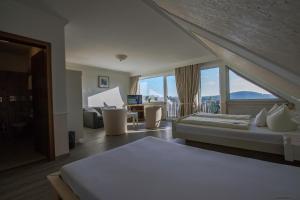 ein Hotelzimmer mit einem Bett und einem großen Fenster in der Unterkunft Hotel Schneider in Winterberg