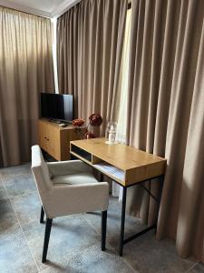 a desk and a chair in a room with curtains at Hotel Art in Varna City