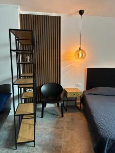 a bedroom with a bed and a chair and a book shelf at Hotel Art in Varna City