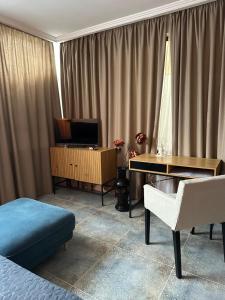 a bedroom with a bed and a desk and a television at Hotel Art in Varna City