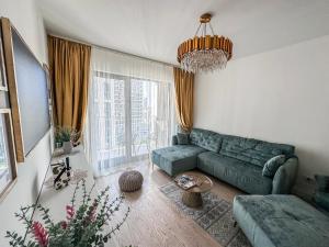 贝尔格莱德SuprStay - Belgrade Waterfront Luxury Apartment的客厅配有绿色沙发和吊灯。