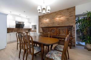 een eetkamer met een houten tafel en stoelen bij Miško Fėja in Birštonas