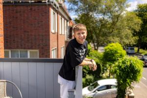 een jonge jongen leunt op een hek bij Visiet - Ferienwohnungen in Emden in Emden