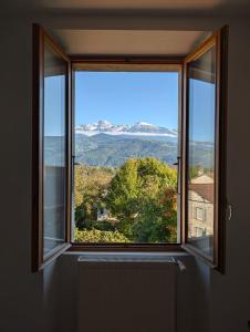 ein offenes Fenster mit Blick auf einen Baum in der Unterkunft INOVALLEE SOITEC STMICRO Appart grand salon avec 2 chambres - Parking gratuit - Vue sur Belledonne in Montbonnot-Saint-Martin