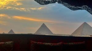 uma vista das pirâmides de Gizé ao pôr-do-sol em pharaohs pyramids view hotel no Cairo