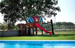 um parque infantil com um escorrega junto a uma piscina em Villa Campi em Pula