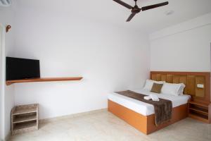 a bedroom with a bed and a flat screen tv at Thomson Imperial Boutique G0A in Calangute