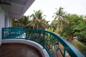 a balcony with a blue railing and palm trees at Thomson Imperial Boutique G0A in Calangute