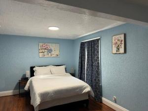 a bedroom with a bed and a blue wall at Getaway at Niagara in Niagara Falls