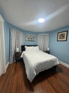 a bedroom with blue walls and a white bed at Getaway at Niagara in Niagara Falls