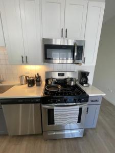 芝加哥Modern Shared Condo Near Downtown Chicago, Flexible Room Options and Shared Amenities的厨房配有炉灶和微波炉。