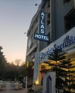 un hôtel avec un panneau sur son côté dans l'établissement Atlas Hotel Islamabad, à Islamabad