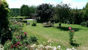 a garden with a table and some flowers at La Passiflore B&B in Bossière