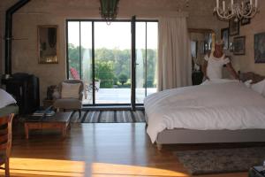 a woman standing on a bed in a bedroom at La Passiflore B&B in Bossière