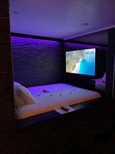 a bedroom with a bed with a tv in it at OCV Infiny in Durbuy