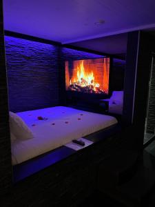 a bedroom with a bed with a fireplace in it at OCV Infiny in Durbuy