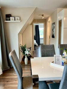 - un salon avec une table et des chaises blanches dans l'établissement Airport Business Apartment, à Norderstedt