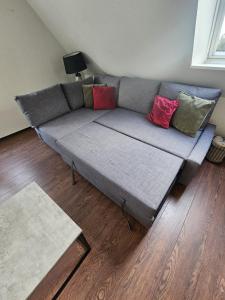 a couch with pillows on it in a living room at Exclusives Apartment im Herzen von Westerland in Westerland (Sylt)