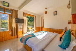 a bedroom with a large bed and a window at Hide-in Old Manali in Manāli