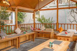 an outdoor patio with wooden tables and benches at Hide-in Old Manali in Manāli