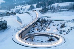 un treno che viaggia lungo un binario nella neve di Hotel Krallerhof a Leogang