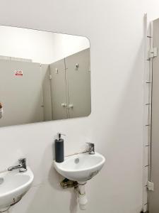 La salle de bains est pourvue de 2 lavabos et d'un miroir. dans l'établissement TomTom Hostel, à Cracovie