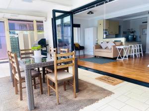 een eetkamer en een woonkamer met een tafel en stoelen bij Citadel Suite in Port Macquarie