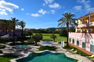 un complejo con piscina y palmeras en Pestana Sintra Golf Resort & SPA Hotel, en Sintra