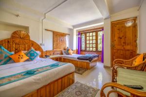 a bedroom with two beds and a window at Hide-in Old Manali in Manāli