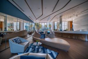 una hall con sedie, divano e tavolo di Hotel Baraquda Heeton Pattaya by Compass Hospitality a Centro di Pattaya