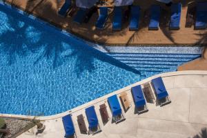 vista sul soffitto di una piscina con sedie blu di Hotel Baraquda Heeton Pattaya by Compass Hospitality a Centro di Pattaya