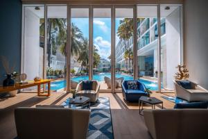 un soggiorno con piscina e una grande finestra di Hotel Baraquda Heeton Pattaya by Compass Hospitality a Centro di Pattaya