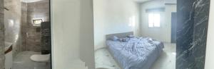 a bedroom with a bed in a room with a shower at Luxury Qurtuba in Nouakchott