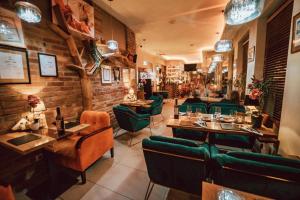 a restaurant with green chairs and tables and a brick wall at Hotel Agit Congress&Spa in Lublin