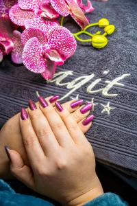 a woman with pink and purple nails and flowers at Hotel Agit Congress&Spa in Lublin