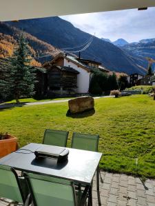 einen Tisch und Stühle mit Bergblick in der Unterkunft Studio 60m2 au pied de la télécabine et SaastalCards in Saas-Fee