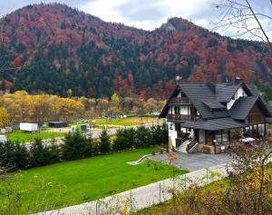 una casa en un campo con una montaña en el fondo en Willa FOLK Pieniny, en Szczawnica