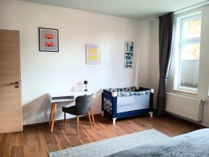 Schlafzimmer mit einem Schreibtisch, einem Bett und einem Tisch in der Unterkunft Ferienwohnung Gemütliche Auszeit - Wallbox, nur 50m zum Hauptbahnhof, ruhig, Parterre, zentral, Hunde willkommen, Kinderausstattung vorhanden in Gotha