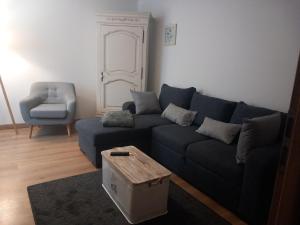 a living room with a blue couch and a chair at Gîte Les Rainettes in Coye-la-Forêt