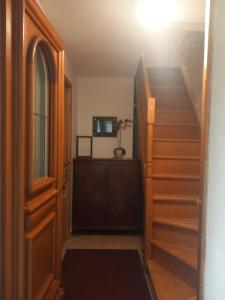 a hallway with a staircase with a door and a window at Gîte Les Rainettes in Coye-la-Forêt