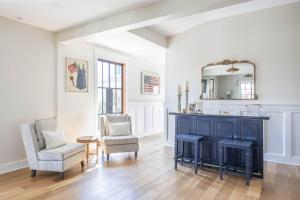 a living room with a blue cabinet and two chairs at The Hen Houses in Wildwood