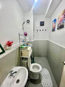 La salle de bains est pourvue de toilettes blanches et d'un lavabo. dans l'établissement Affordable Condotel in Cebu, à Cebu