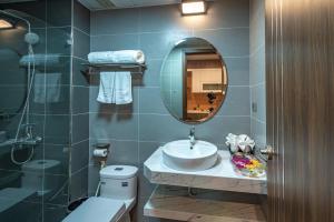 uma casa de banho com um lavatório, um espelho e um WC. em ZEN RIVERSIDE HOTEL & RESIDENCES em Hai Phong