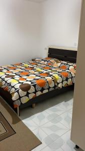 uma cama num quarto com um edredão colorido em Aleko Guesthouse em Përmet