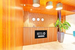 ラーイプルにあるSuper Hotel O Raipur formerly Singhania Premiereの木製の壁にホテルの看板が貼られたロビー