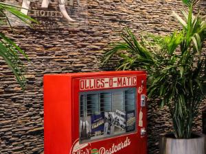 Une machine rouge assise sur le côté d'un bâtiment dans l'établissement Mercure Hotel Tilburg Centrum, à Tilbourg