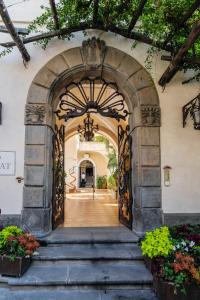 einen Eingang zu einem Gebäude mit einem Torbogen und Blumen in der Unterkunft Hotel Palazzo Murat in Positano