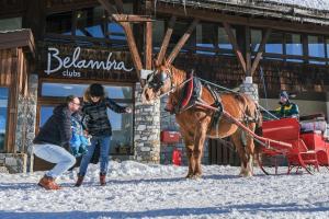 een vrouw die naast een paard staat in de sneeuw bij Belambra Clubs Avoriaz - Les Cimes du Soleil in Avoriaz